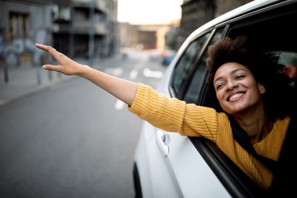 A person reaching their hand out of the passenger side window of an electric vehicle.